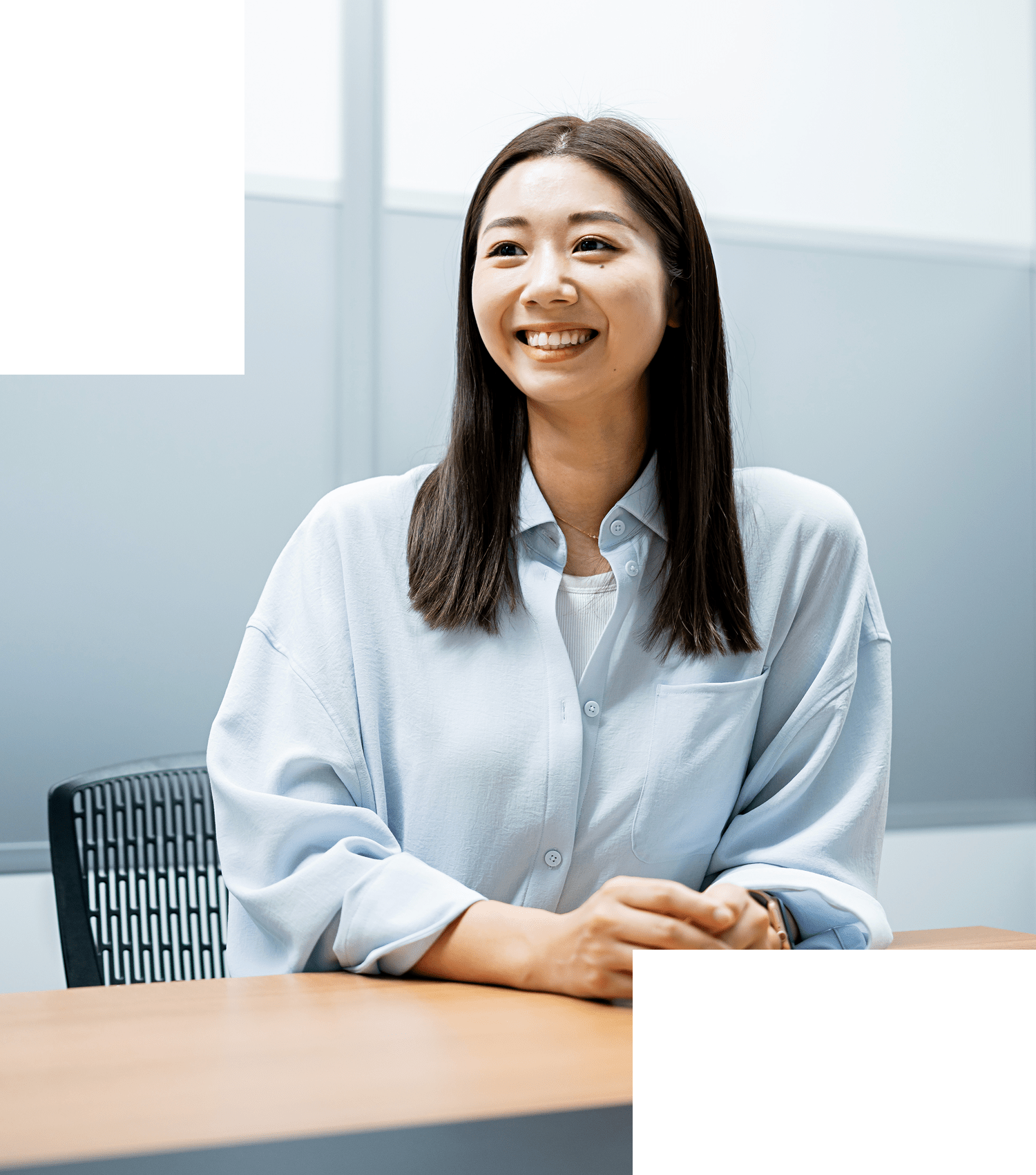 白いトップスを着た女性がテーブルに手を置いて話している様子